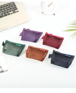 Detailed macro view of five colorful mesh nylon triangle pouches arranged on a clean white desk