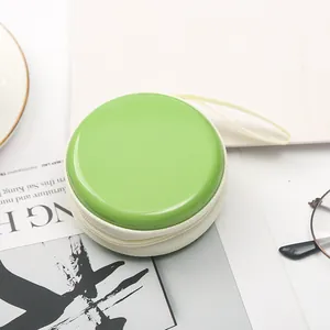 Vista ravvicinata di un piccolo portamonete verde in latta stile macaron con cerniera lampo.