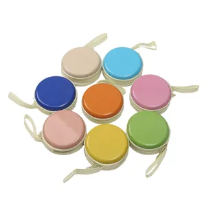 Dettaglio di otto portamonete rotondi colorati in latta macaron per gli auricolari