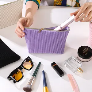 Detailansicht einer lila Cord-Kosmetiktasche, die mit Beauty-Zubehör gefüllt wird.