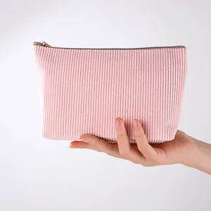 Detailaufnahme einer rosa Cord-Kosmetiktasche, die in der Hand gehalten wird zur Größe.
