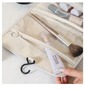 Primo piano dell'interno di un beauty case da viaggio appeso con trucchi organizzati