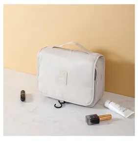 Vista dettagliata della borsa da toilette da viaggio color crema con gancio funzionale.