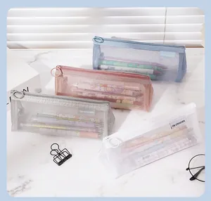 Detail of four transparent mesh pencil bags in various colors filled with stationery