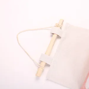 Dettaglio dell'organizer da parete in cotone e lino con asta in legno e corda