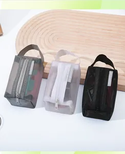 Detail view of portable nylon mesh storage pouches in grey, white, and black colors