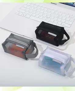 Three portable mesh storage pouches in grey black and white on a clean desk