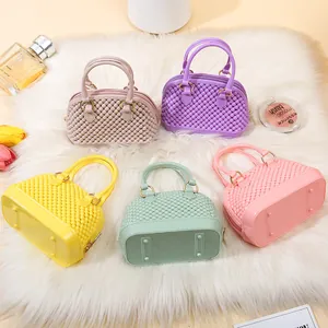 Set of mini PVC jelly shell handbags in colorful pastel shades on white faux fur rug