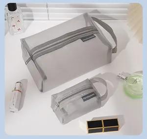 Close-up detail of gray nylon mesh travel cosmetic bags in two sizes for toiletries