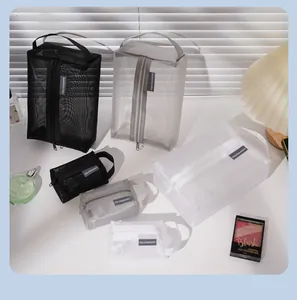 Various sizes of mesh makeup organizers in black, grey, and white colors on a white table.