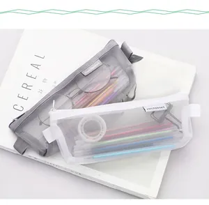 Close-up detail of minimalist white and grey mesh pencil bags showing texture and storage