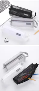 Detailed view of black, grey and white mesh pencil cases with stationery items