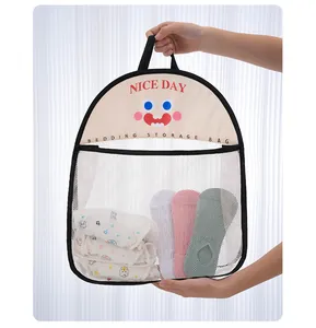 Close-up of a hanging mesh storage bag with a cartoon face being held by hands