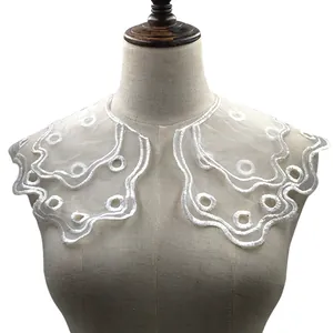 Close-up of white double-layered organza embroidered lace collar with floral patterns.