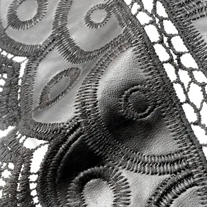 Detailed macro view of black leather applique and water-soluble lace embroidery