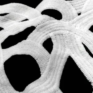 Macro detail of white water-soluble lace with intricate 3D embroidery textures