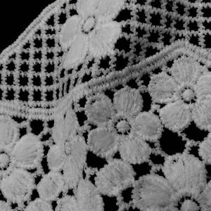 Macro detail of white water-soluble lace floral embroidery with hollow-out design