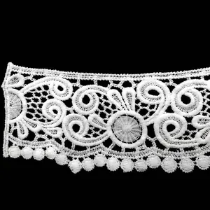 Close-up of white water-soluble milk silk lace trim with intricate hollow-out embroidery detail
