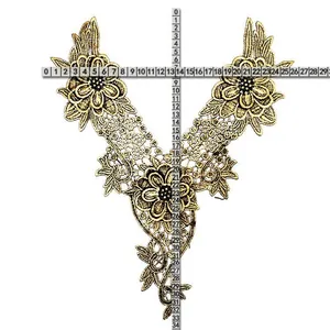 Detailed macro view of golden embroidered lace collar with size measurements shown by rulers