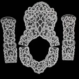 Set of four white lace appliques featuring intricate floral embroidery on black background