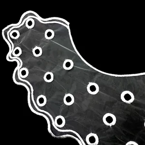 Detailed close-up of a white organza embroidered lace collar with elegant wavy edges