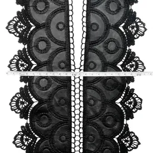 Detailed macro view of black water-soluble lace collar with leather embroidery and ruler
