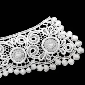 Macro view of white water-soluble lace collar featuring 3D hollow embroidery motifs