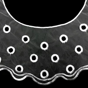 Close-up of white organza embroidered fake collar with delicate circular eyelet pattern