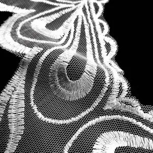 Detailed macro view showing the intricate texture of white water-soluble lace embroidery.
