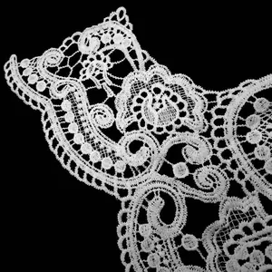 Macro view showing the intricate texture of a white water-soluble lace collar detail