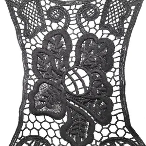 Macro view of black water-soluble lace floral embroidery detail on white background.
