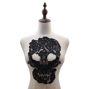 Intricate black lace skull-shaped embroidery patch detail displayed on white mannequin torso