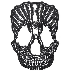 Macro detail showing intricate embroidery of black skull lace patch