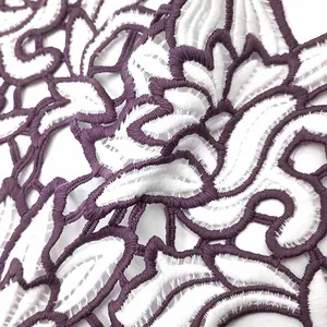 Close-up of two-tone purple and white water-soluble lace patch with hollow flower design