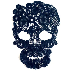 Detailed view of an intricate black skull lace embroidery patch with floral motifs