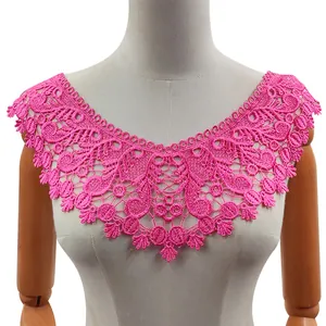 Dettaglio dell'applique per scollatura in pizzo rosa acceso esposta su un manichino