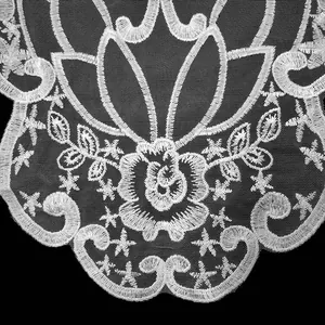 Detailansicht des weiß bestickten Spitzenkragens aus Polyester mit Rosenblütenmotiven.