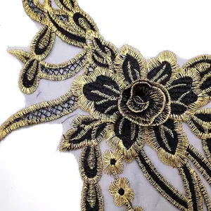 High-detail macro shot of elegant black and gold floral embroidery lace applique patch on mesh