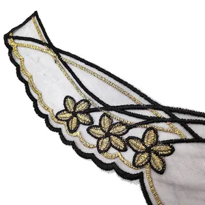 Detailed close-up of gold embroidered flower lace trim on black mesh base