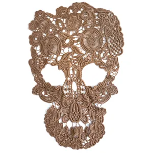Detailed view of a brown hollow-out lace skull embroidery patch with floral patterns.