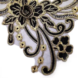 Detailed close-up of gold and black embroidered lace collar patch with floral pattern