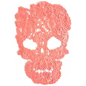 Close-up view of a coral peach skull lace patch with intricate floral water-soluble embroidery