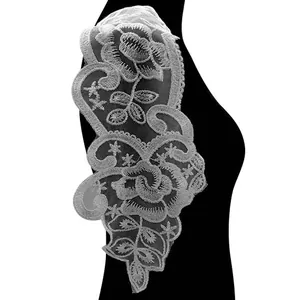 Nahaufnahme einer weißen Spitzenapplikation mit aufwendigen floralen Stickmustern