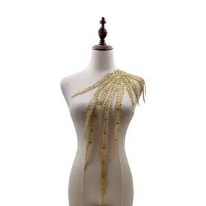 Detailweergave van gouden wateroplosbaar kant borduurwerk met feniksstaart op mannequin
