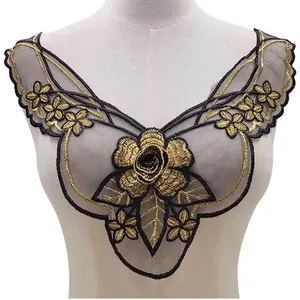 Detail of black and gold embroidered lace collar applique on a white mannequin torso.