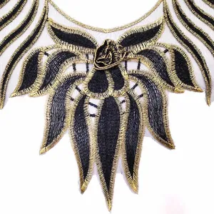 Macro detail of exquisite black and gold embroidered floral lace collar patch for DIY clothes.