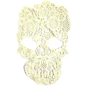 Detailed macro view of a cream skull shaped milk silk lace embroidery patch for DIY