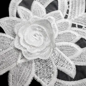 Close-up of white water-soluble lace flower applique with delicate embroidery textures.