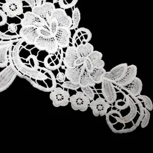 Detailed macro view of delicate white milk silk water-soluble embroidered floral lace trim