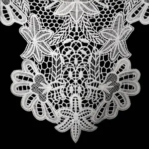 Close-up detail of white water-soluble lace floral applique with intricate embroidery